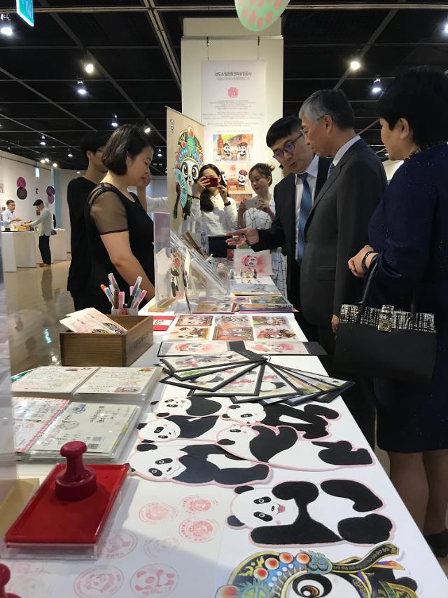 邱國洪大使在展示會現場聽取工作人員介紹參展文創商品