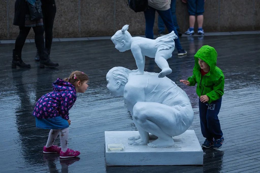 兩個外國小朋友圍繞著肥女雕塑《童趣》在玩耍.jpg